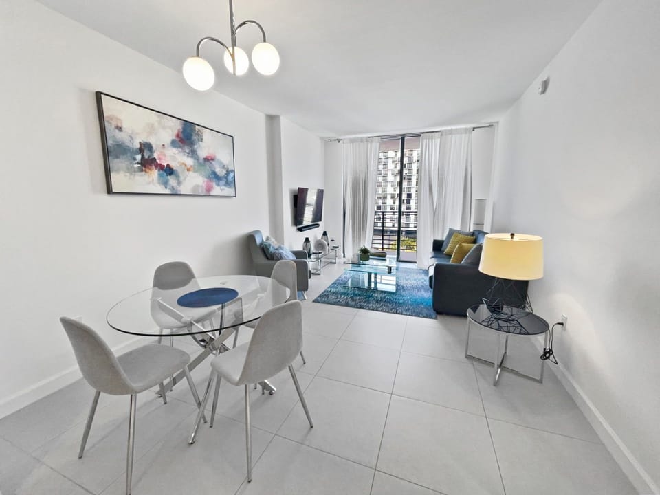 Relax in the cozy living area, with plush seating and natural light pouring in through the balcony doors.