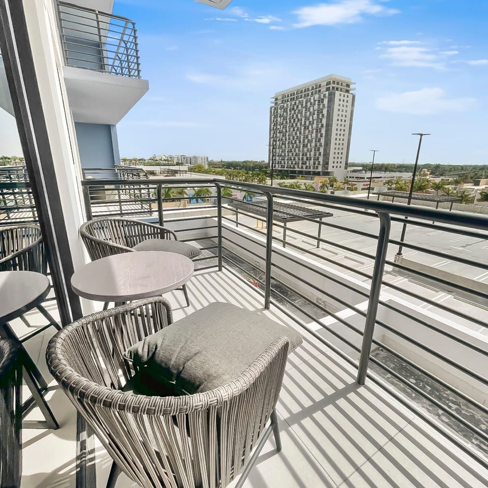 Step onto your private balcony with sleek seating, perfect for morning coffee.