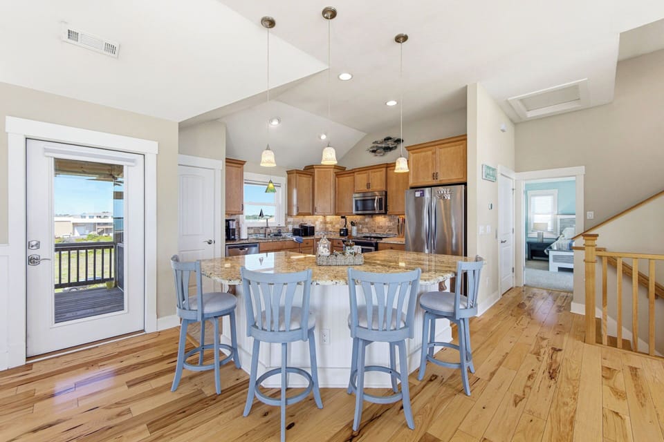 Bright open kitchen with granite island seating and vaulted ceilings