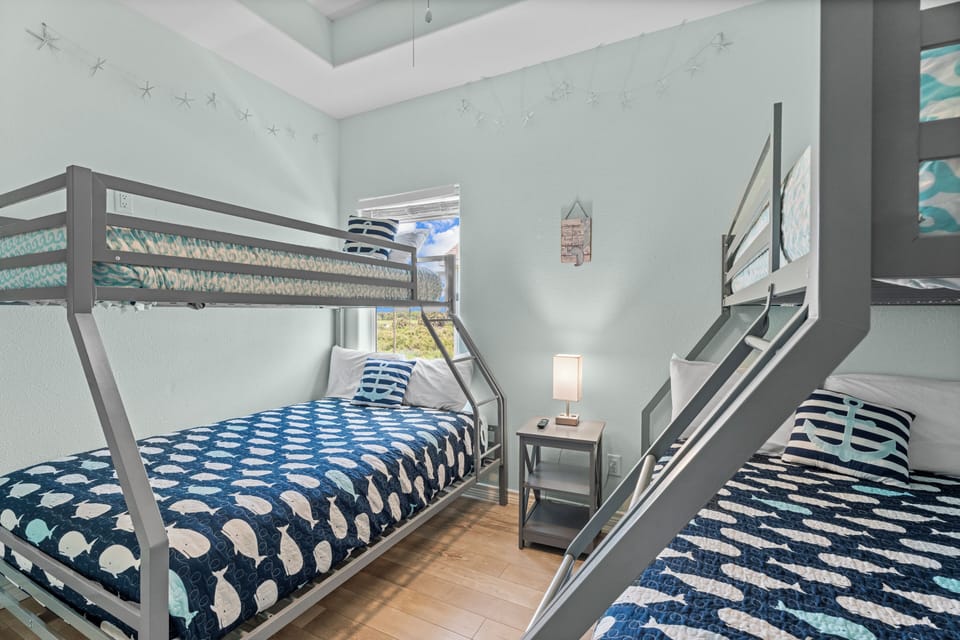 Large bunk bedroom with multiple sleeping spaces, coastal décor, and family-friendly layout ideal for large vacation groups.