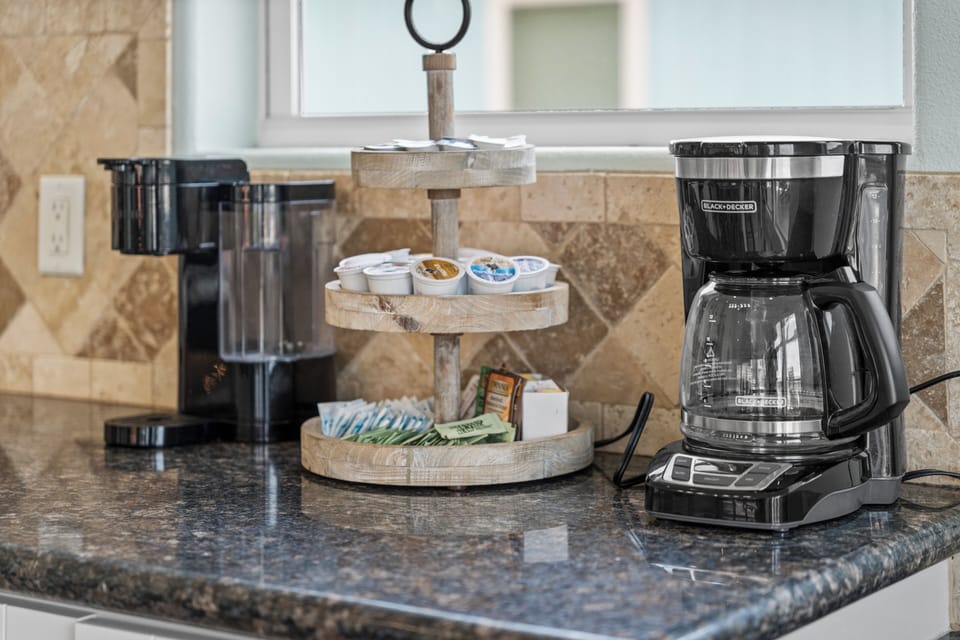 Kitchen coffee station with drip coffee maker, countertop appliances, and convenient setup for morning coffee during your beach getaway.
