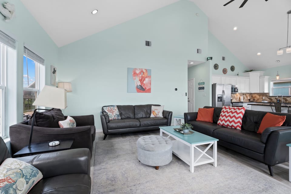Spacious coastal living space featuring comfortable seating, modern décor, and easy access to the fully equipped kitchen and dining area.
