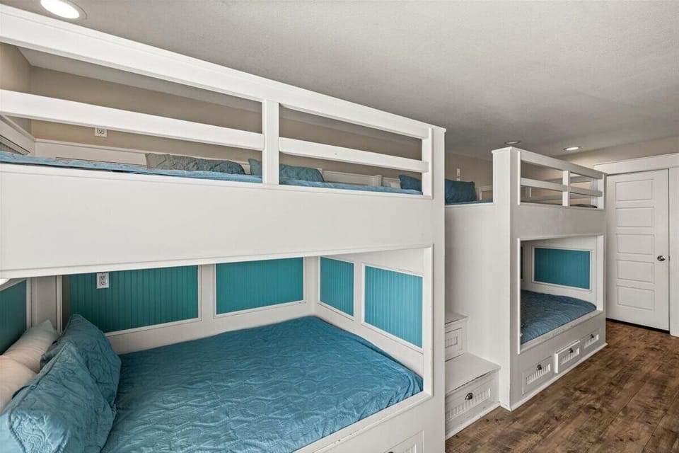 Custom bunk bedroom with multiple built-in bunk beds and bright coastal accents, ideal for large family vacations near Crystal Beach.