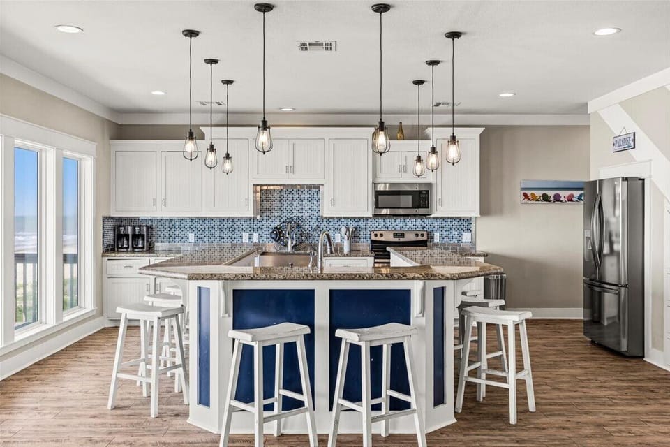 Coastal kitchen and dining area with oversized island seating, pendant lighting and open entertaining space perfect for large family meals and gatherings.