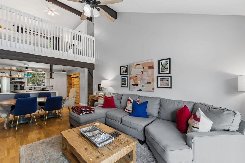 Spacious living room with wood burning fireplace, smart TV, and walkout patio overlooking the golf course