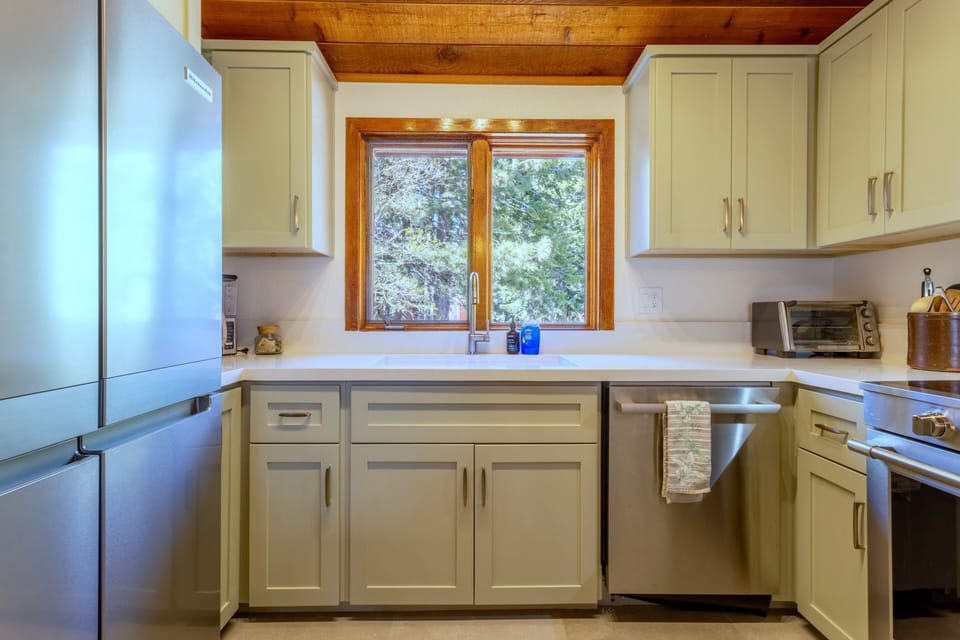 Kitchen has solid quartz countertops and new stainless steel appliances.