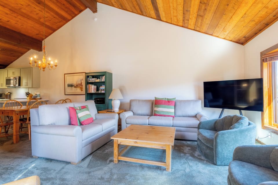 Living room has new furnishings and opens to dining area.