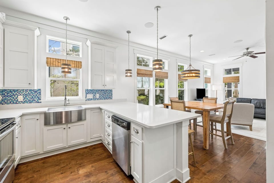 Step into your dream vacation kitchen, where coastal-chic meets comfort. Gleaming countertops, stainless appliances, and charming pendant lights create the perfect space for cooking meals with your group.