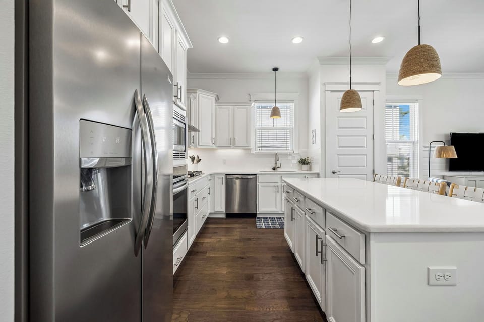 Step into your bright, modern kitchen with stainless steel appliances, sleek white cabinetry, and a spacious island perfect for cooking and gathering with loved ones.