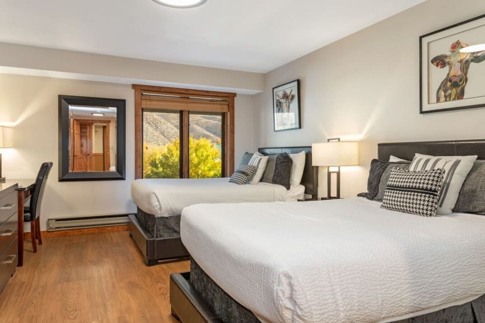 Two Queen beds with en suite bathroom and TV in hotel-style suite