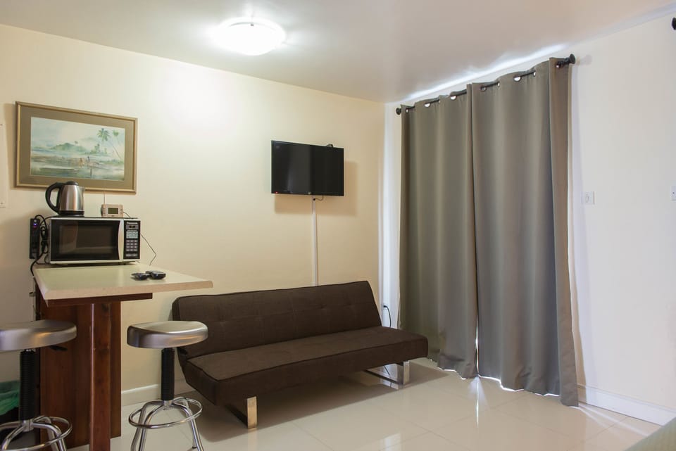 Deluxe Studio, 1 King Bed, Beachside | Living room | Flat-screen TV