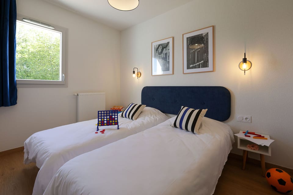 The second bedroom with twin beds is perfectly suited for children or friends sharing — comfortable, bright, and just steps from the resort's pools and activities.