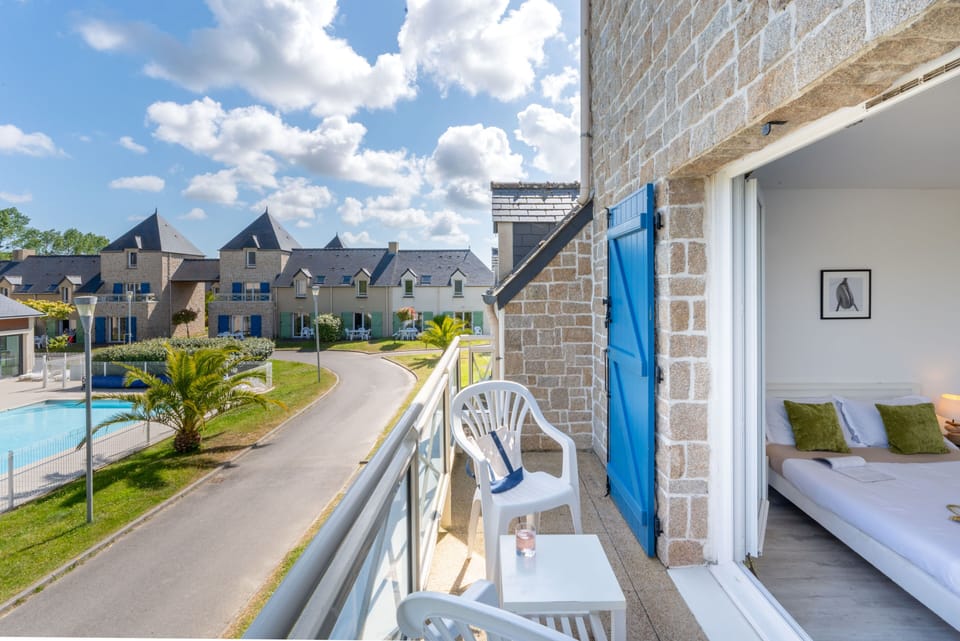 The private balcony looks out over the outdoor pool and the residence's sunny grounds — your own front-row seat to the action.