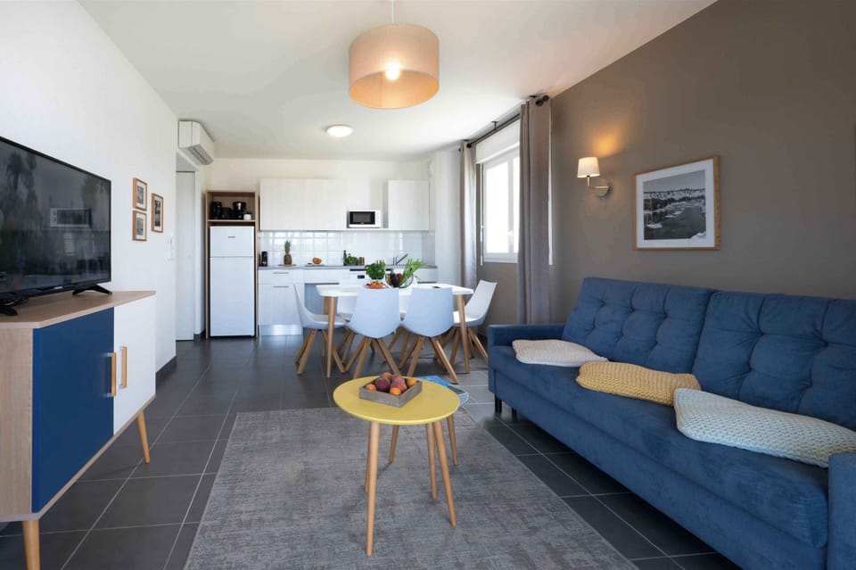 Bright living space with a comfortable sofa bed and modern furnishings, offering a relaxed Mediterranean atmosphere for your stay.