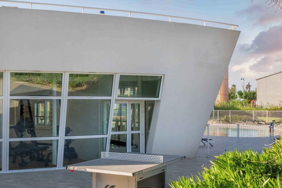 The modern architecture of Le Cap Azur opens onto a beautifully landscaped patio, where the outdoor pool and the Mediterranean backdrop await.