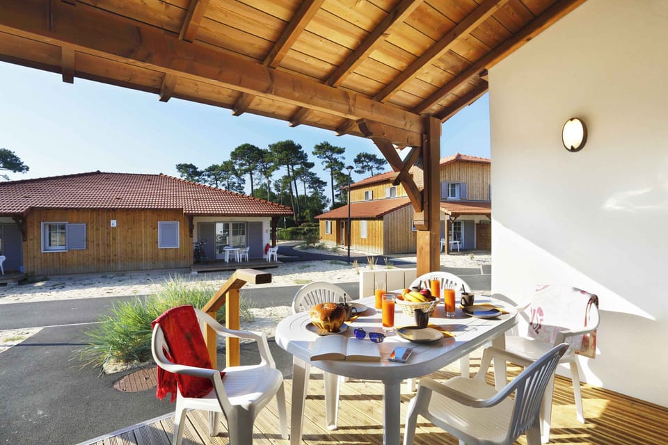 Furnished terrace shaded by Landes pines — a good spot for morning coffee before heading 500m down to the beach.