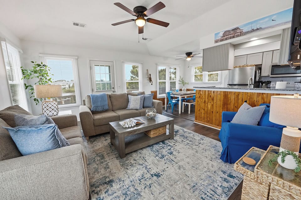 Bright coastal living with open kitchen, dining, and deck access