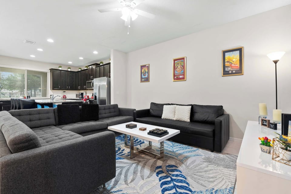 Modern living room with ample seating and an open kitchen layout for family gatherings.