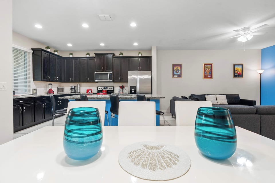 Modern kitchen with dark cabinetry and a spacious island overlooking the living area.