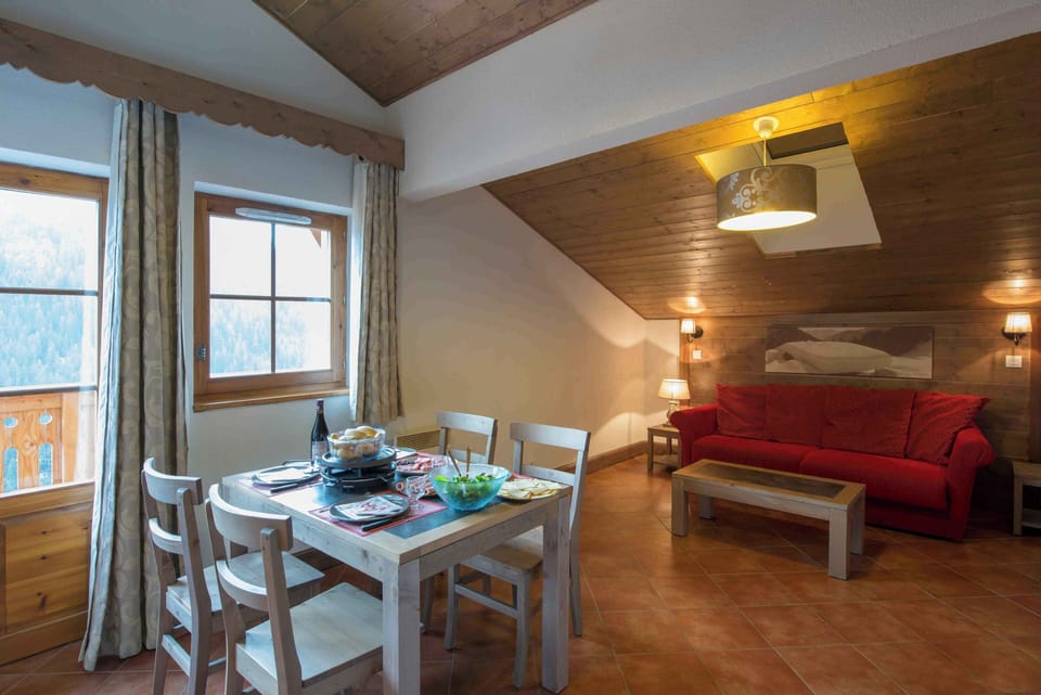 The open-plan dining and living space bathed in natural alpine light — the ideal setting for a relaxed family dinner after a day in the Portes du Soleil.