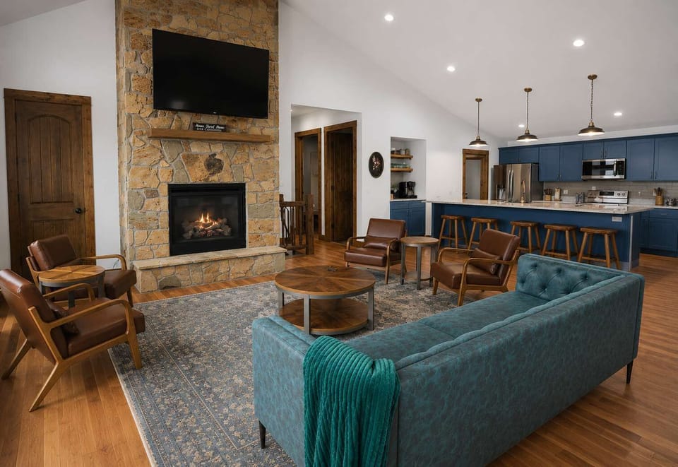 The open concept living room with a stone fireplace  is a perfect place to relax after your day in the sun