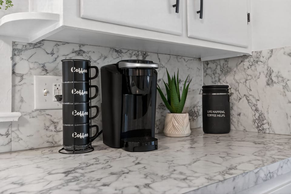 Chic marble coffee station with single-serve maker and guest-ready mugs
