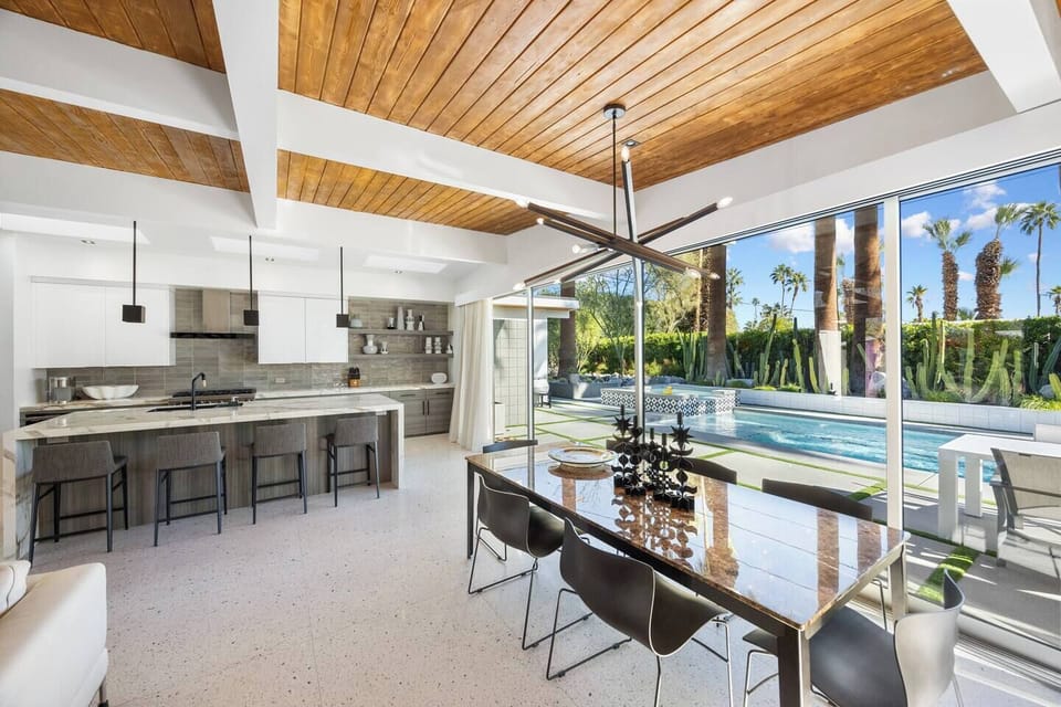 Kitchen and dining area opening fully to the pool terrace — where indoor luxury meets outdoor living.