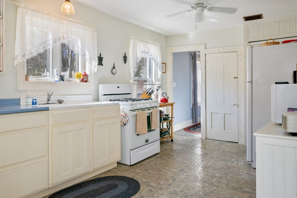 The entryway leads directly into our farmhouse kitchen, maintaining the original 1870 layout of this historic Somes family home. Enjoy modern utility with a full-sized refrigerator and microwave in a space rooted in Somesville's history.