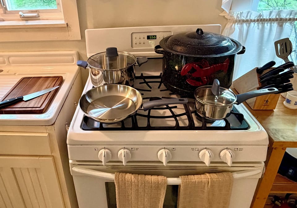 A fully equipped kitchen featuring gas cooking, a classic Maine lobster pot, brand-new stainless cookware, and a premium J.A. Henckels knife set. Everything a home chef needs to prepare fresh local seafood after a day in Acadia.