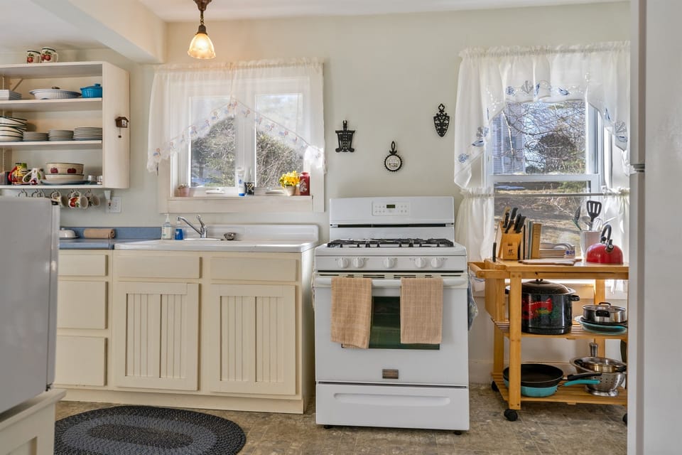 Cook a traditional Maine feast in our farmhouse kitchen, featuring a propane stove and lobster pot. This space balances 1870s character with modern essentials like a microwave and toaster, perfect for prepping trail snacks before heading into Acadia.