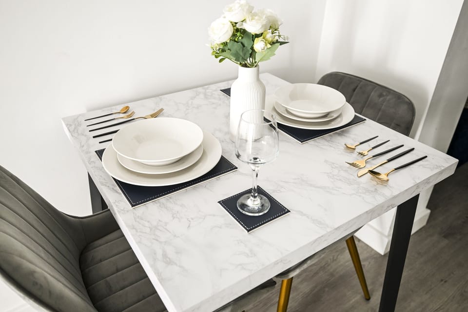 The table for two close up, laid with crockery and glassware