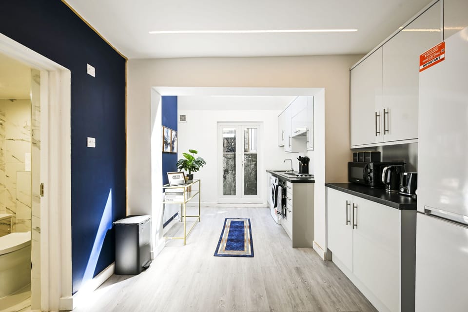 Galley kitchen running down to the glazed doors at the end, with the bathroom just off it