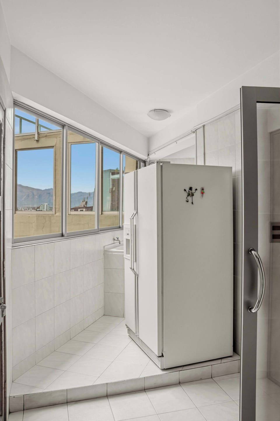 refrigerator is located in hallway to laundry room