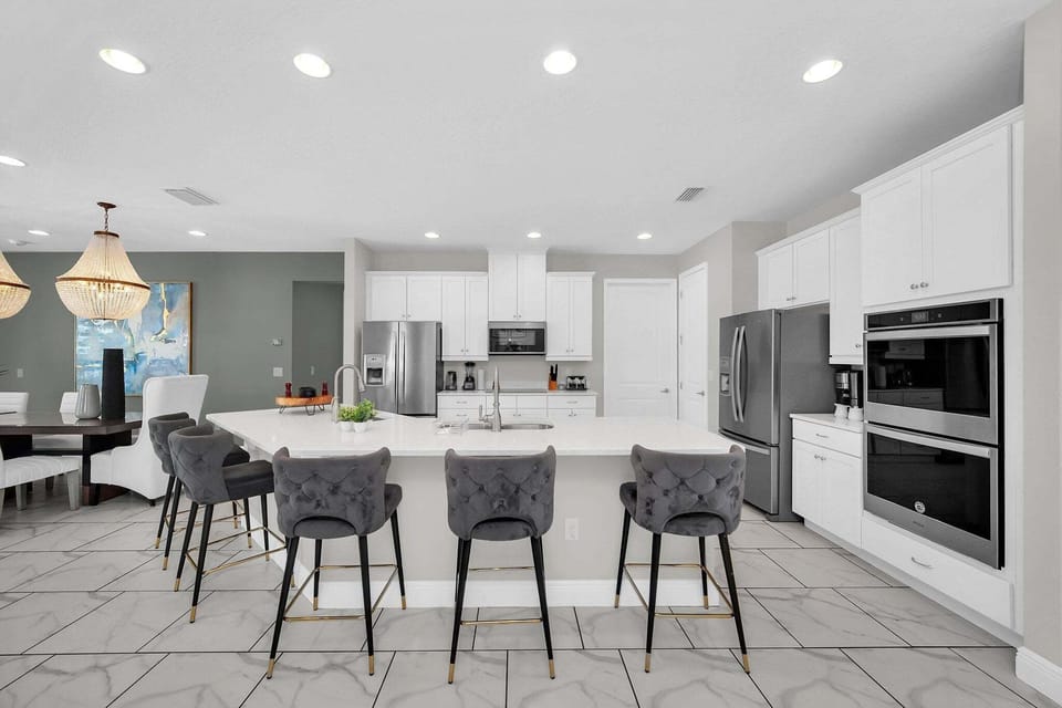 Kitchen area w/ large island and stainless-steel appliances