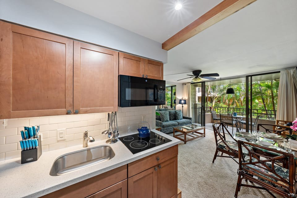 Kitchen carries wood cabinetry and steel, counters lined with everyday essentials.