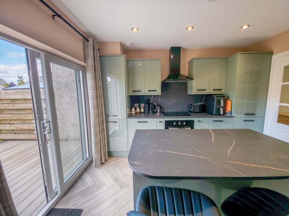 A beautifully designed open plan kitchen filled with natural light from the large patio doors. Whether you're whipping up a Scottish breakfast or a quick snack, this stylish space makes cooking a pleasure.