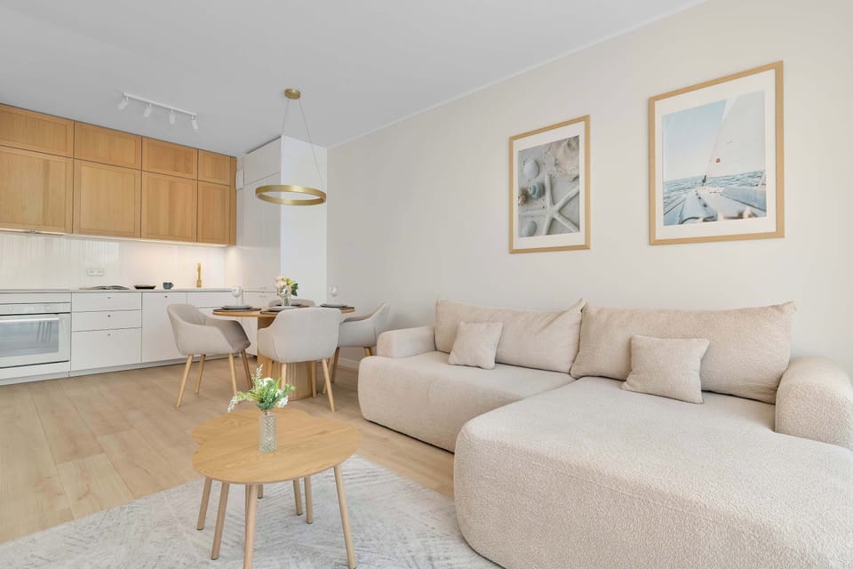A bright open-plan living area with a comfortable sofa and fully equipped kitchenette.