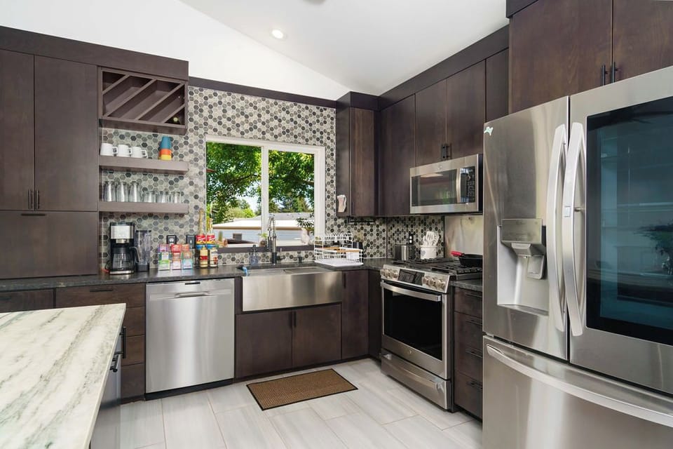 Fully stocked kitchen with modern GE appliances, gas range with griddle and a no pre-heat air fry function makes quick meals easy! the windows from the kitchen overlook the back deck, patio, and garden. 