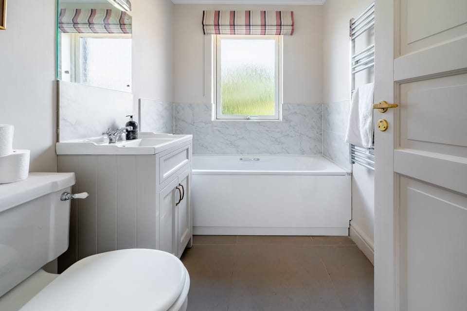 Ground floor: En-suite bathroom with bath with handheld shower