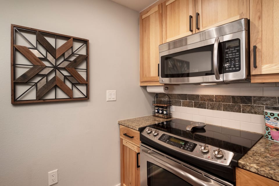 Your well-appointed kitchen features stainless steel appliances, granite countertops, and warm wood cabinetry—ready for preparing your favorite vacation meals.