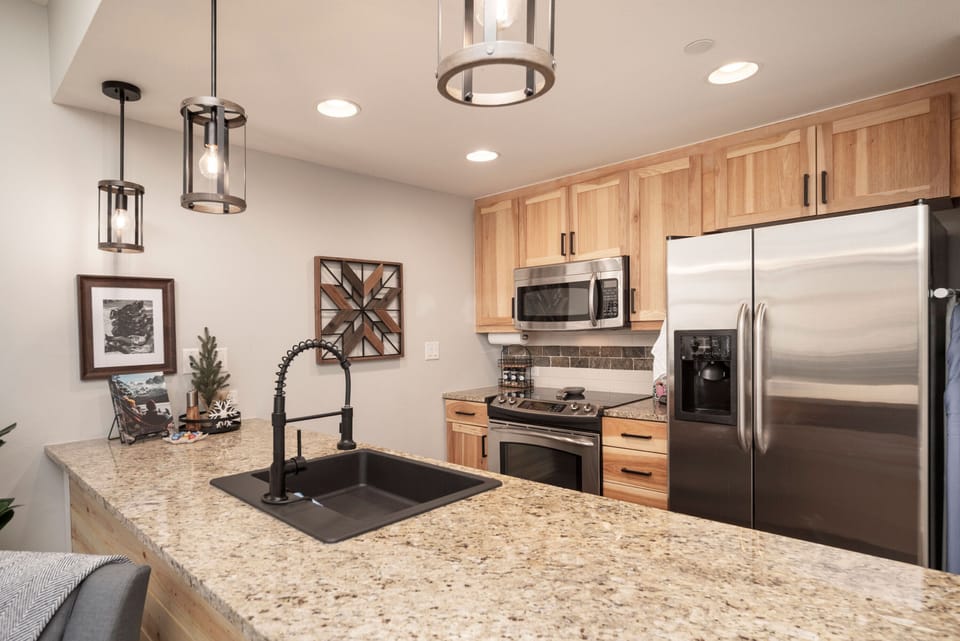 Your fully equipped kitchen makes meal prep a breeze with stainless steel appliances, granite countertops, and warm wood cabinetry—perfect for cozy gatherings or morning coffee as you plan your day.