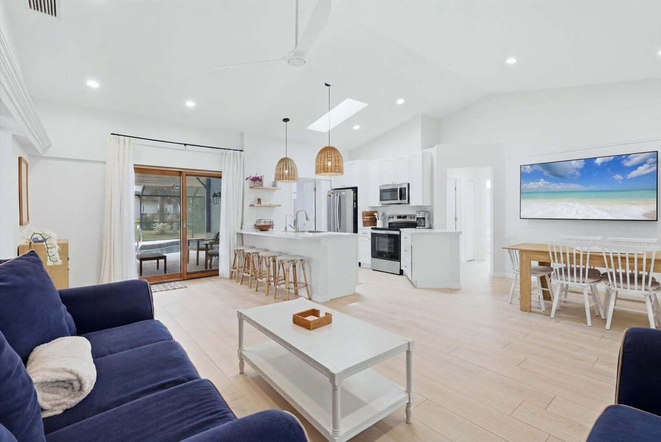 Bright, open living space with comfy seating, 75-inch Smart TV, and lanai access