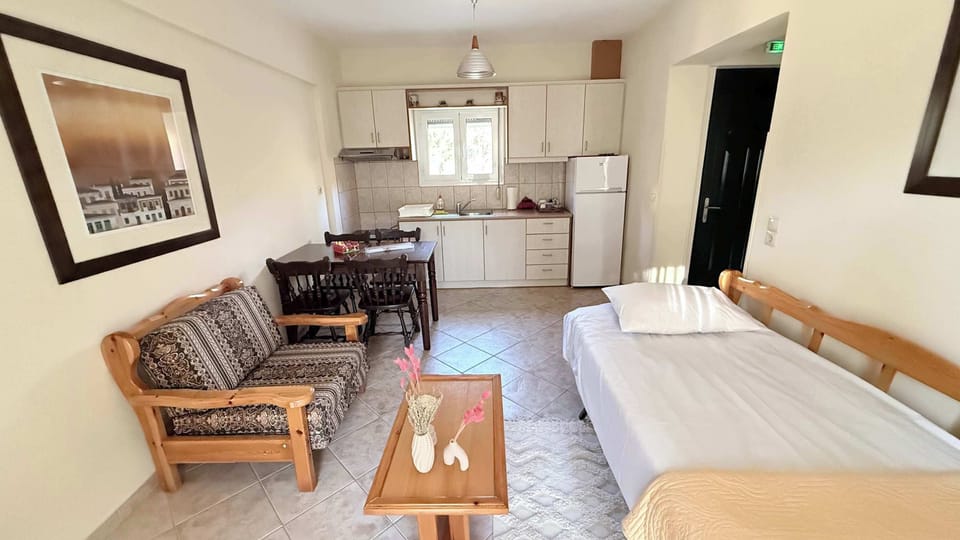 Spacious open-plan living and dining area featuring comfortable seating, a fully equipped kitchen, a TV and modern air-conditioning 