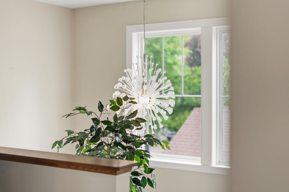 Bright natural light pours through the windows, illuminating your space with a warm, welcoming glow and framing views of lush greenery outside.