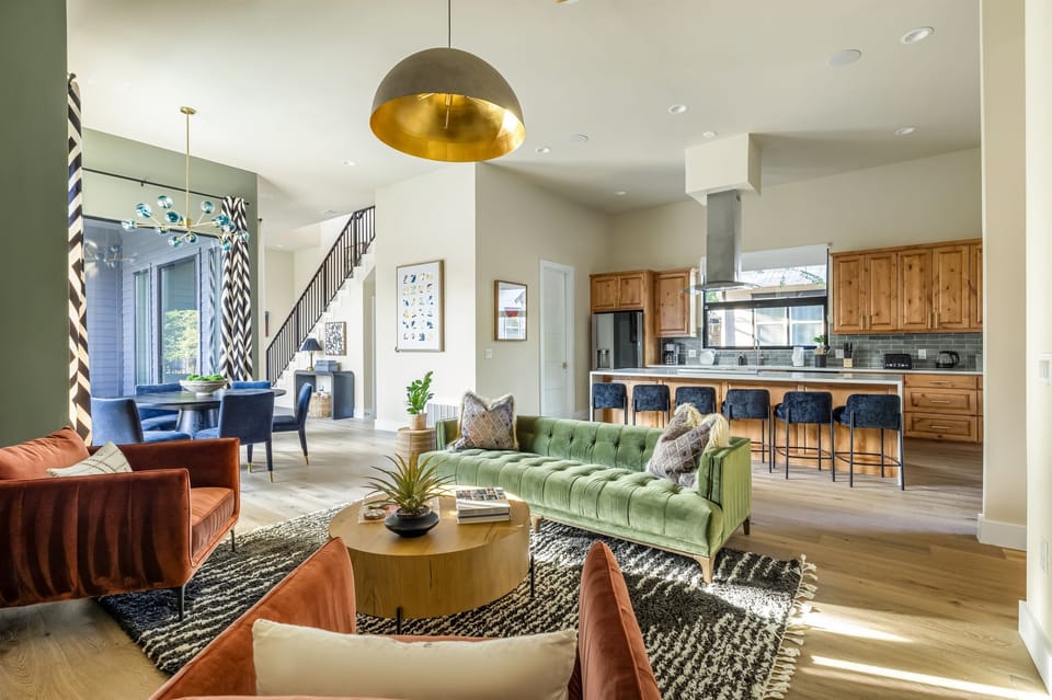 Spacious open-concept living room with stylish furnishings, high ceilings, and seamless access to the kitchen and dining areas, perfect for entertaining and group gatherings.