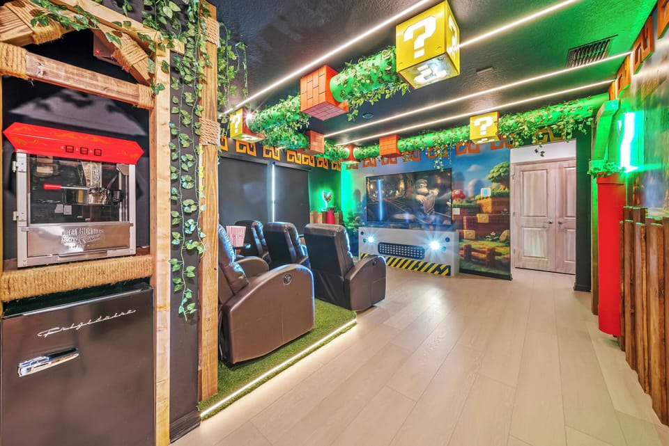 Welcome to our lively game-themed lounge, featuring cozy reclining chairs and bright green accents. The playful decor and soft lighting create an inviting atmosphere, ideal for relaxing after a day full of adventure.