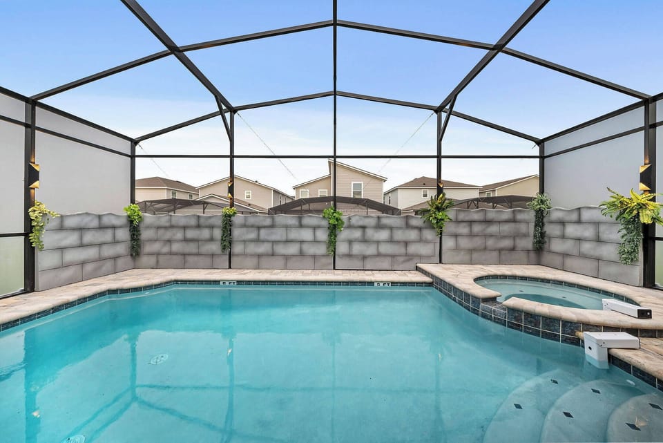 Step into your own private oasis with a sparkling pool surrounded by a sleek screened enclosure. The inviting blue water reflects the natural light, while lush greenery adds a touch of tranquility to your relaxing escape.