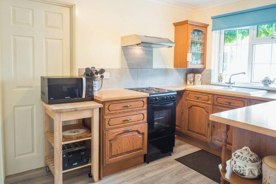 Wooden kitchen units with black oven and cooker hood