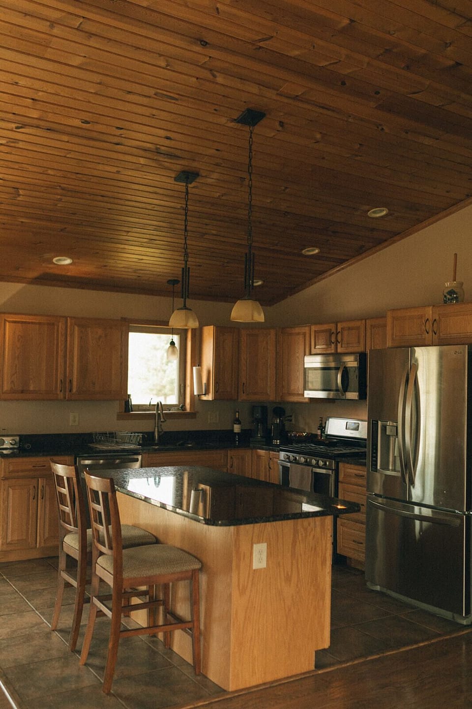 Kitchen with island and 2 barstools