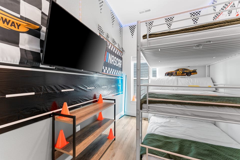 The racecar-themed bunk room includes three full-size beds—great for kids, teens, or even adults to sleep in fun and comfort.